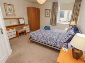 A bedroom with a bed, wardrobe, and dresser at Kittiwake at No 20 Seahouses