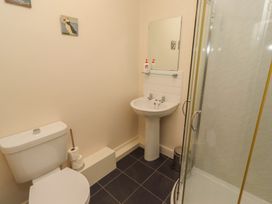 A bathroom with a shower, sink, and toilet at Kittiwake at No 20 Seahouses