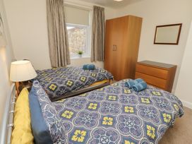 A bedroom with two beds and a wardrobe at Kittiwake at No 20 Seahouses