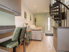 A living room with a sofa and a staircase at The Annex At The Barn in Pelynt