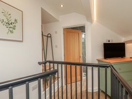 A landing with a staircase and door at The Annex At The Barn in Pelynt