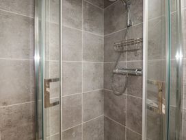 A shower enclosure with wall tiles and fittings at The Annex At The Barn in Pelynt