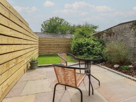A garden with a table and chair at The Annex At The Barn in Pelynt