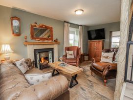 A living room with a sofa, table and fireplace at Ingleside Cottage in Whitby