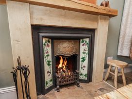 A fireplace with wood and flames at Ingleside Cottage in Whitby