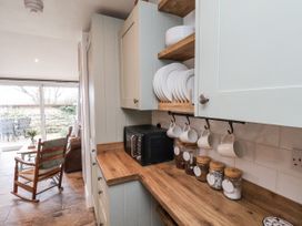 A kitchen with cabinets and a microwave at Ingleside Cottage in Whitby