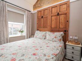 A bedroom with a bed and wooden doors at Ingleside Cottage in Whitby