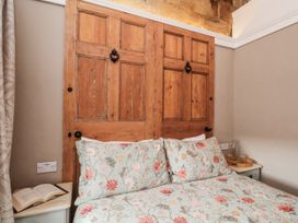 A bedroom with a bed and wooden door at Ingleside Cottage in Whitby