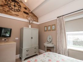 A bedroom with a wardrobe and television at Ingleside Cottage in Whitby