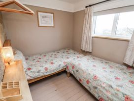 A bedroom with two beds and a table at Ingleside Cottage in Whitby