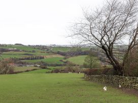 A landscape with a tree, field, and farmhouse at Ingleside Cottage in Whitby