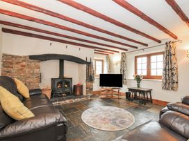 A living room with a television and a fireplace at Little Blagdon in Beaworthy