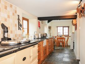A kitchen with an island, stove, sink, and dining table at Little Blagdon in Beaworthy