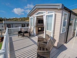 A deck with chairs and an entrance at Devon Cliffs Holiday Park - Holiday Accommodation 14142 in Exmouth