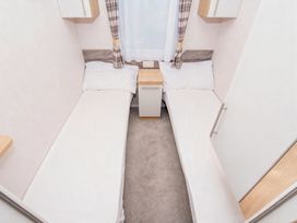 A bedroom with two beds and a nightstand at Devon Cliffs Holiday Park - Holiday Accommodation 14142, Exmouth