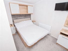 A bedroom with a double bed and television at Devon Cliffs Holiday Park - Holiday Accommodation 14142, Exmouth