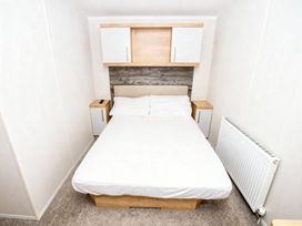 A bedroom with a bed and storage cabinets at Devon Cliffs Holiday Park - Holiday Accommodation 14142 Exmouth