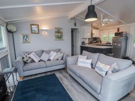 A living room with two sofas and a kitchen area at Lodge 134 Lon Bryn Mair near Bellech