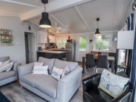 A living room with a sofa and dining area at Lodge 134 Lon Bryn Mair near Bellech