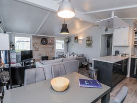 A living room with a sofa and dining table at Lodge 134 Lon Bryn Mair near Bellech