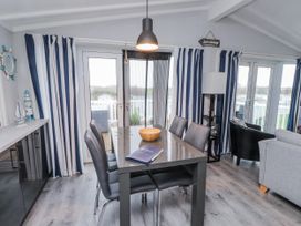 A dining room with a table and chairs at Lodge 134 Lon Bryn Mair near Bellech