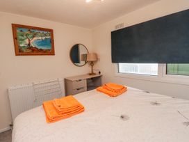 A bedroom with a bed and orange towels on top at Lodge 134 in Lon Bryn Mair near Bellech