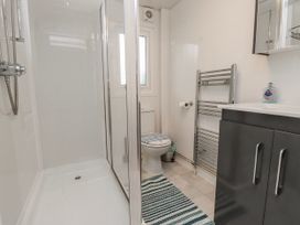 A bathroom with a shower and toilet at Lodge 134 Lon Bryn Mair near Bellech