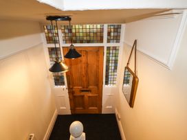 A hallway with a wooden door and stained glass windows at Waterhead Cottage in Ambleside