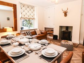 A dining room with a table set for dinner at Waterhead Cottage, Ambleside
