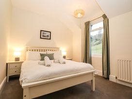 A bedroom with a bed, bedside tables and a window at Waterhead Cottage in Ambleside