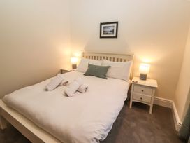 A bedroom with a bed and nightstand at Waterhead Cottage in Ambleside