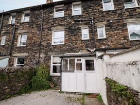 An outdoor view of Waterhead Cottage with stone walls and an entrance in Ambleside
