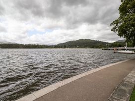 A view of a lake with mountains and a dock at Waterhead Cottage in Ambleside