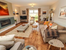 A living room with a sofa, coffee table, and television at Lakes View in Keswick