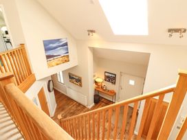 A hallway with a staircase and table at Lakes View in Keswick