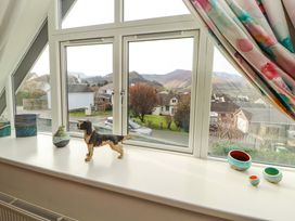 A living room window with a dog figurine and decorative items at Lakes View in Keswick