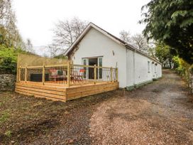 A house with a wooden deck and a gravel path at Inglewood Bach in Conwy