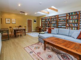 A living room with a sofa and dining area at Inglewood Bach in Conwy