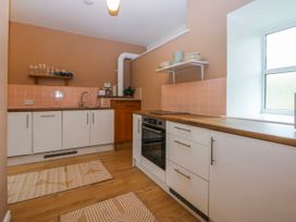 A kitchen with a sink and cooker at Inglewood Bach in Conwy