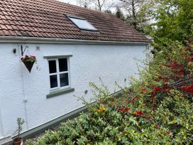 A house with a window and flower pot in a garden at Inglewood Bach in Conwy