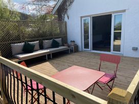An outdoor seating area with a bench and table at Inglewood Bach in Conwy