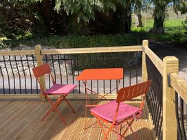 An outdoor seating area with a table and chairs at Inglewood Bach in Conwy
