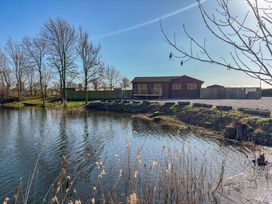 A water body with a building and trees at Star Carr Lakes