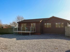 A house with a deck and gravel area at Star Carr Lakes