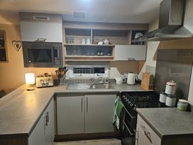 A kitchen with a sink and stove at Homeslea 33 Millennium Gardens in Morpeth