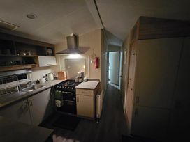 A kitchen with a stove and sink at Homeslea 33 Millennium Gardens Morpeth