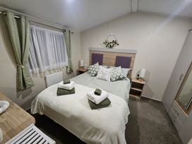 A bedroom with a bed and bedside table at Homeslea 33 Millennium Gardens in Morpeth