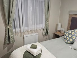 A bedroom with a bed and curtains at Homeslea 33 Millennium Gardens in Morpeth