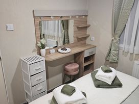 A bedroom with a dressing table and storage unit at Homeslea 33 Millennium Gardens in Morpeth