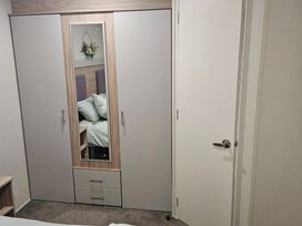 A wardrobe with a mirror and drawers at Homeslea 33 Millennium Gardens in Morpeth